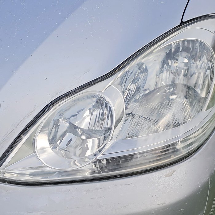 Restored car headlight on a silver vehicle.