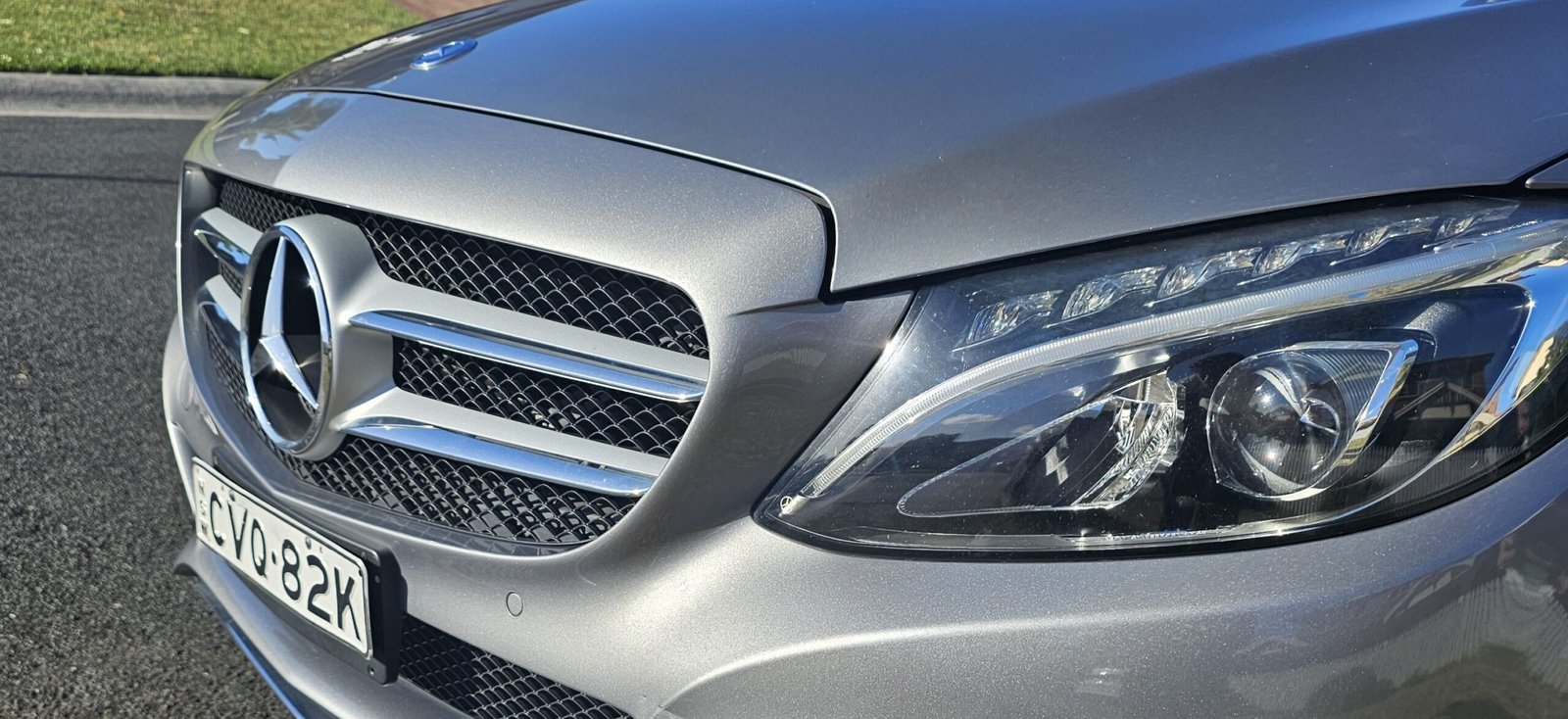 Close-up of a Mercedes-Benz front grille and headlight after a detailing service.